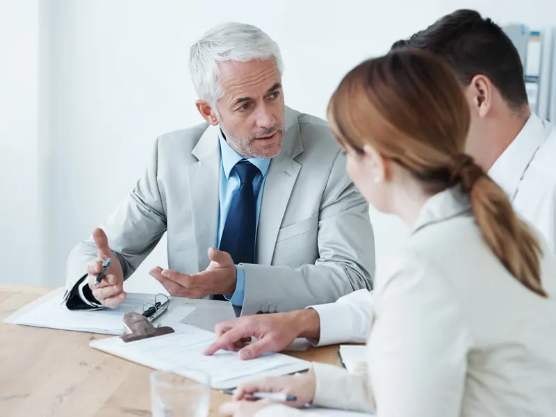 Asesor explicando a dos clientes cómo presentar su reclamación